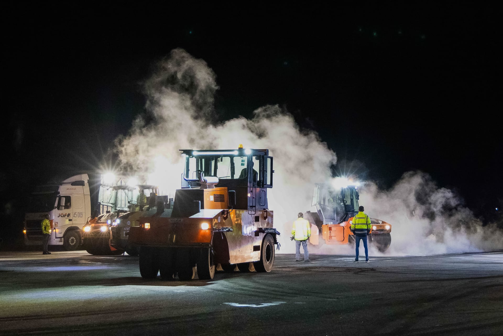 Cilindro compactador em operação noturna na pista