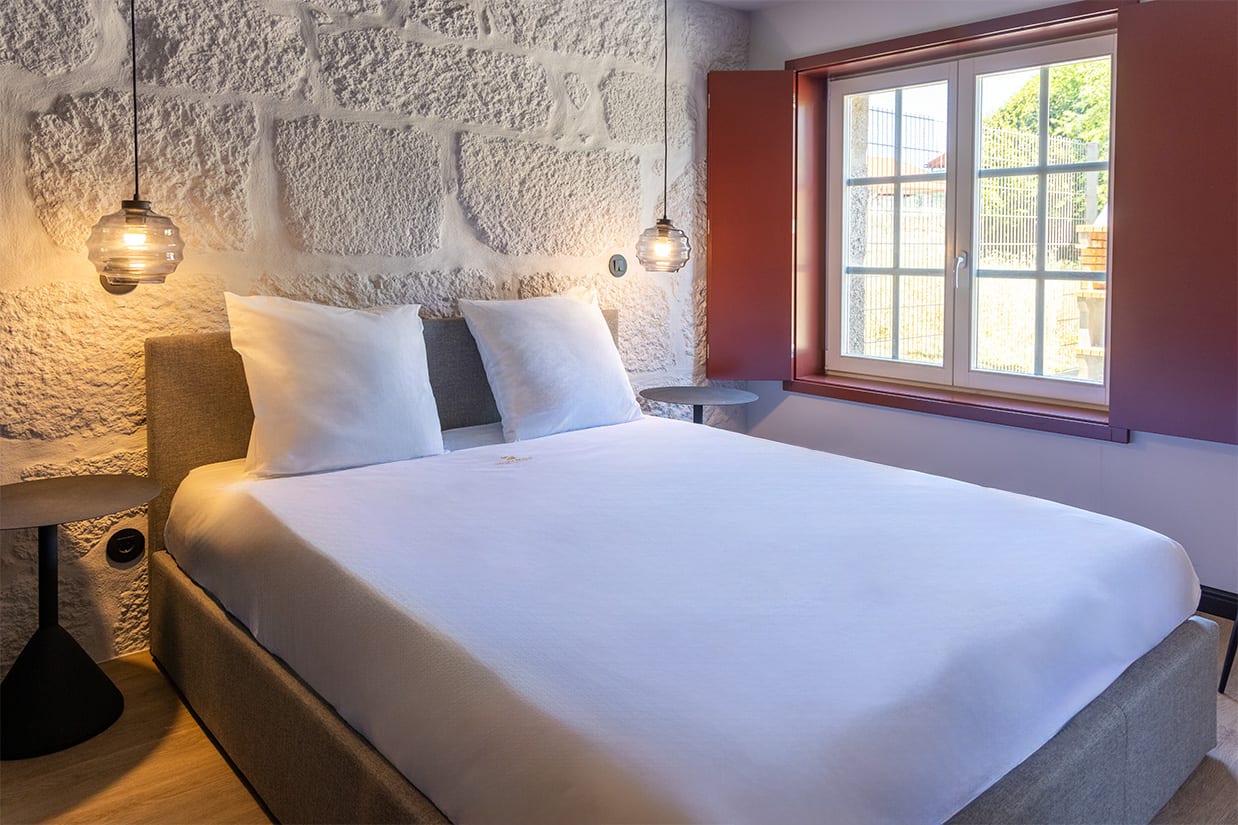 Quarto com parede em pedra, Apartamentos Rua da Liberdade, Guimarães