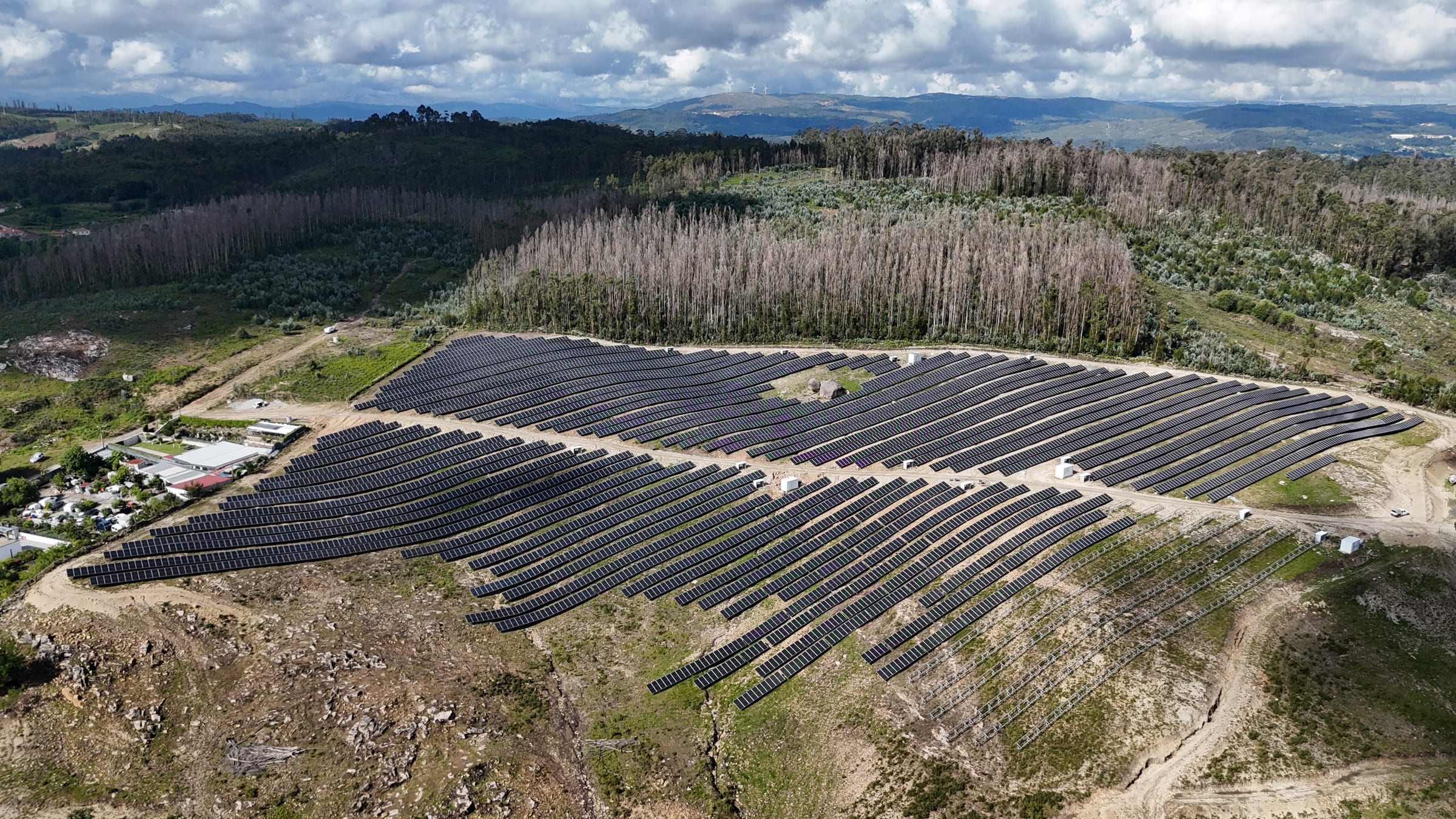 Extenso campo de painéis fotovoltaicos a acompanhar o declive da encosta