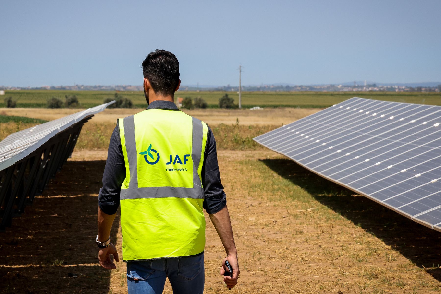 Técnico JAF junto a filas de painéis fotovoltaicos