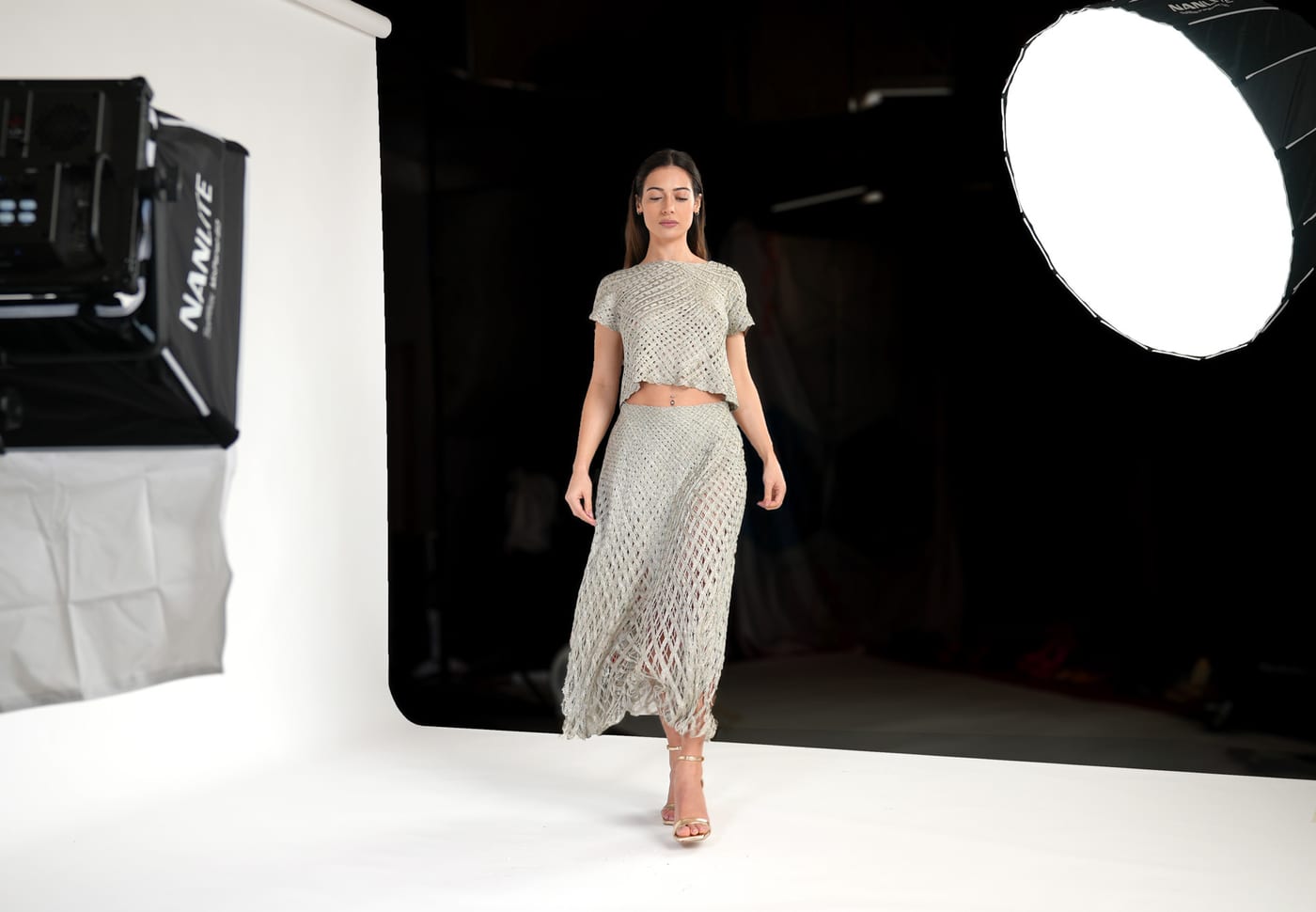 Sessão de moda em curso no estúdio, com modelo sobre fundo branco contínuo e iluminação de estúdio